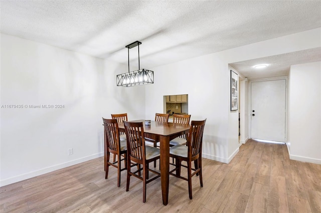 dining space featuring a textured ceiling and light hardwood / wood-style floors