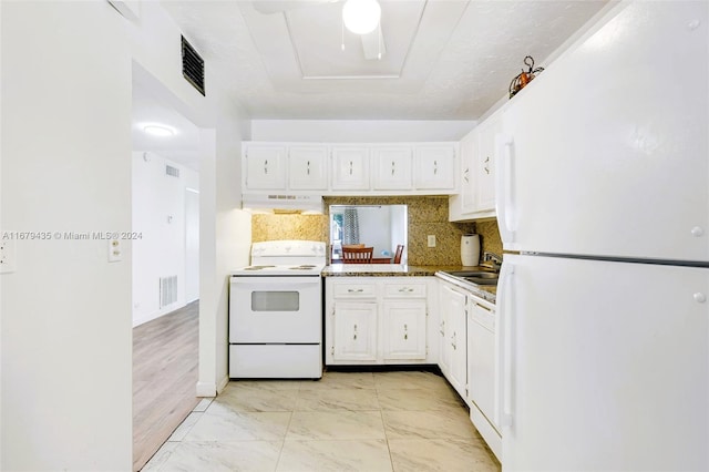 kitchen with white cabinets, light hardwood / wood-style flooring, custom range hood, sink, and white appliances