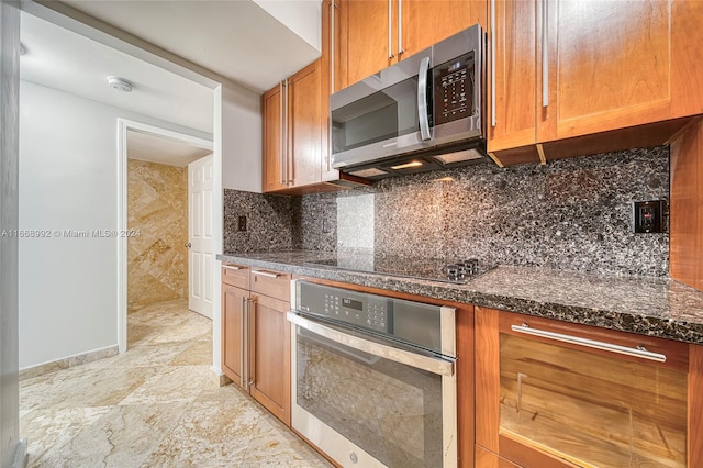 kitchen with decorative backsplash, stainless steel appliances, and dark stone counters