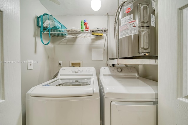 clothes washing area featuring electric water heater and separate washer and dryer