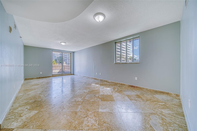 unfurnished room featuring a textured ceiling