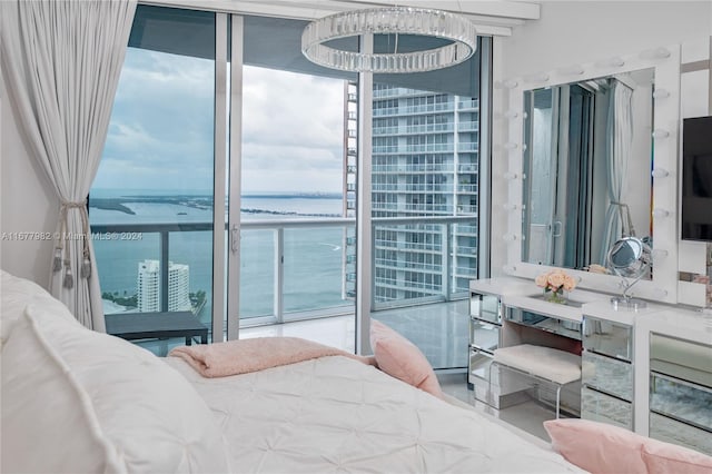 bedroom featuring floor to ceiling windows and a water view