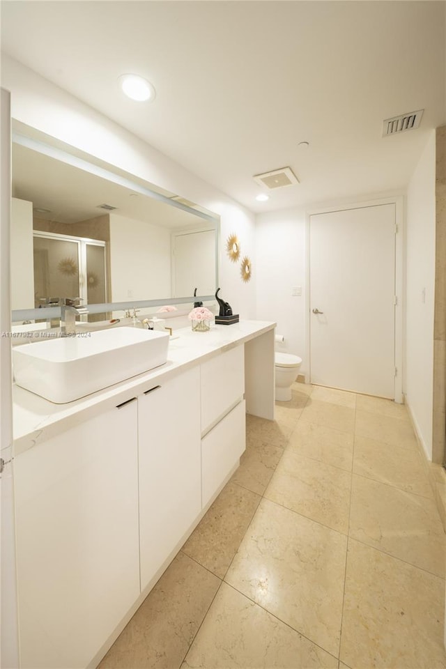 bathroom with vanity, toilet, tile patterned floors, and walk in shower