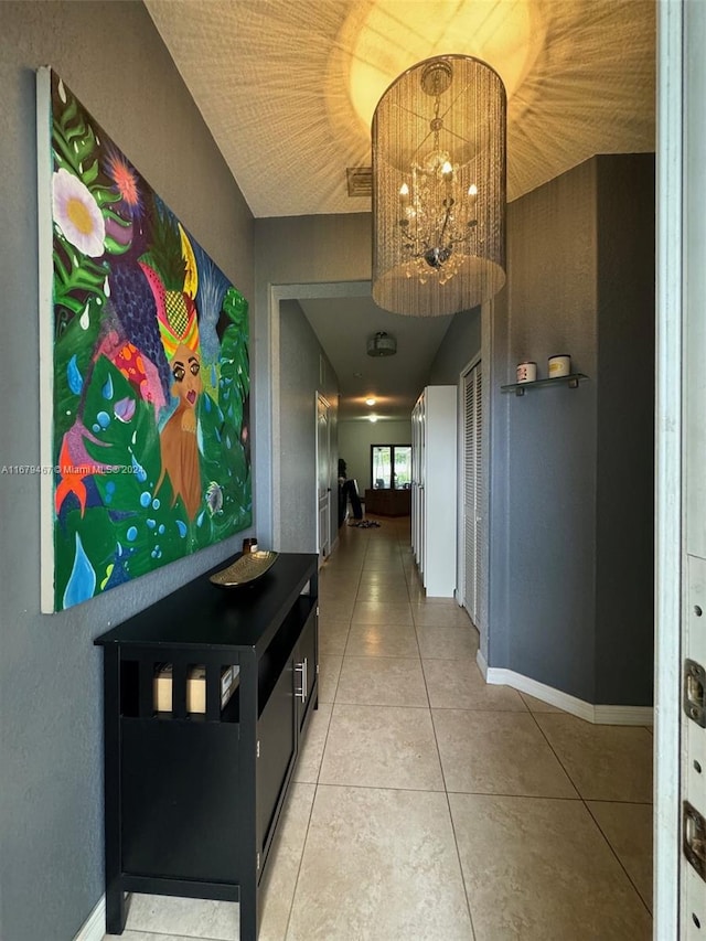 hallway featuring a notable chandelier and tile patterned flooring