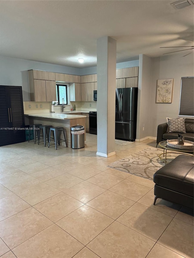 tiled living room with ceiling fan and sink