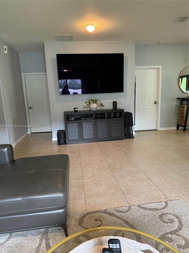 tiled living room featuring a textured ceiling