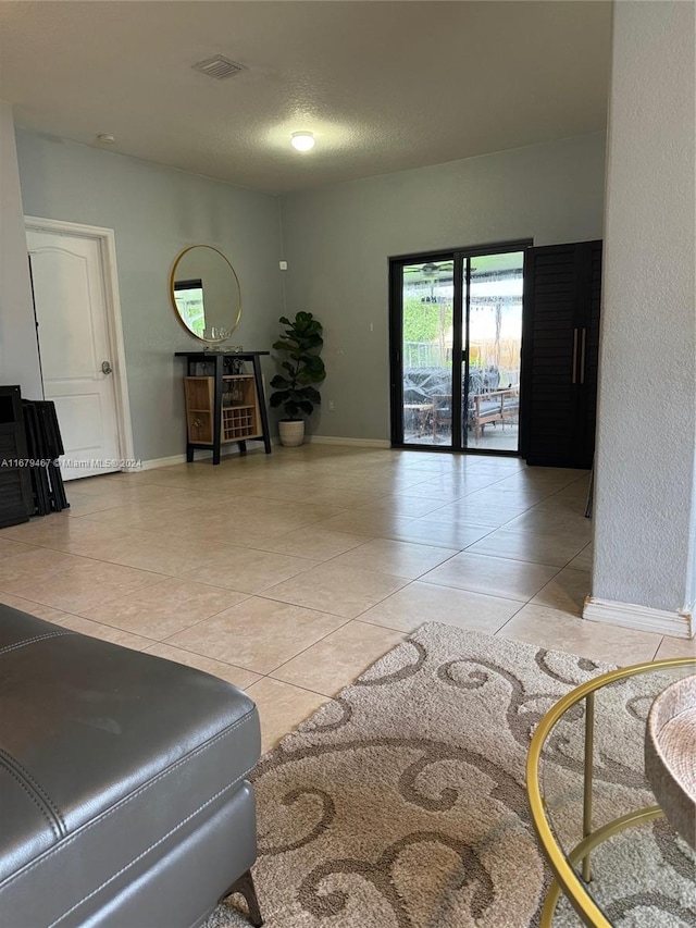 living room with a textured ceiling and light tile patterned floors