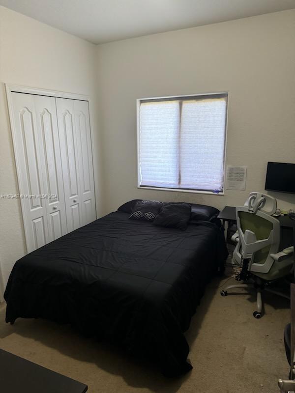 carpeted bedroom with a closet