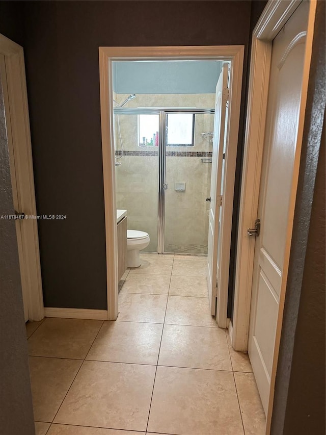 bathroom featuring vanity, tile patterned floors, a shower with shower door, and toilet