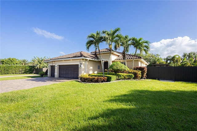 mediterranean / spanish-style house featuring a front yard and a garage