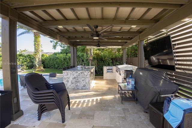 view of patio with an outdoor kitchen, sink, grilling area, and ceiling fan