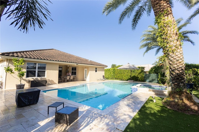 view of swimming pool featuring an in ground hot tub and a patio area