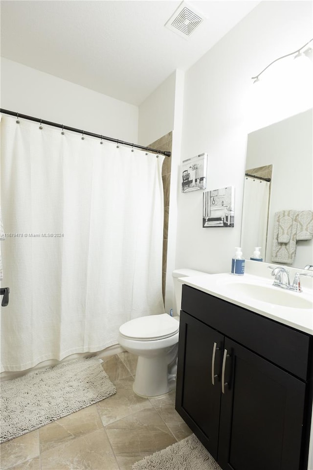 bathroom featuring vanity, a shower with shower curtain, and toilet