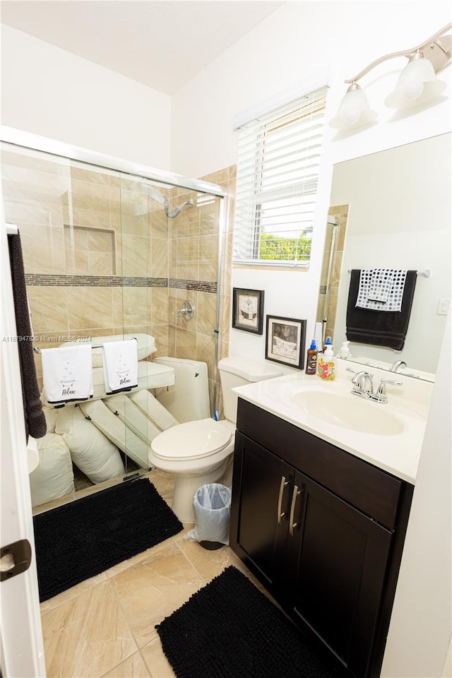 bathroom with vanity, a shower with shower door, and toilet