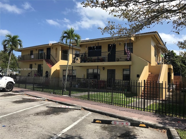 view of front of property featuring a front yard and a balcony