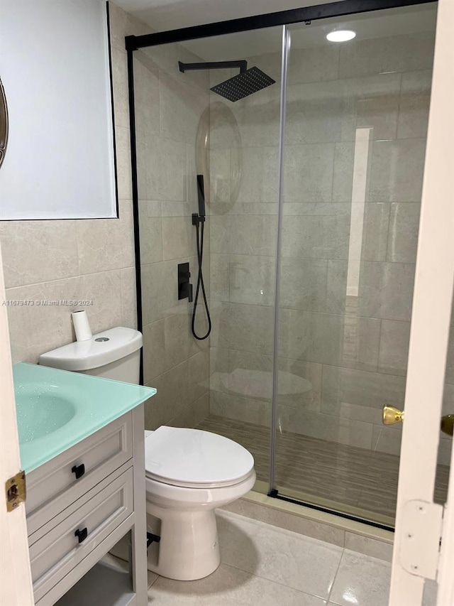 bathroom featuring vanity, walk in shower, toilet, and tile patterned floors