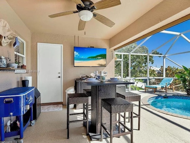 view of patio / terrace featuring an outdoor bar, ceiling fan, and glass enclosure