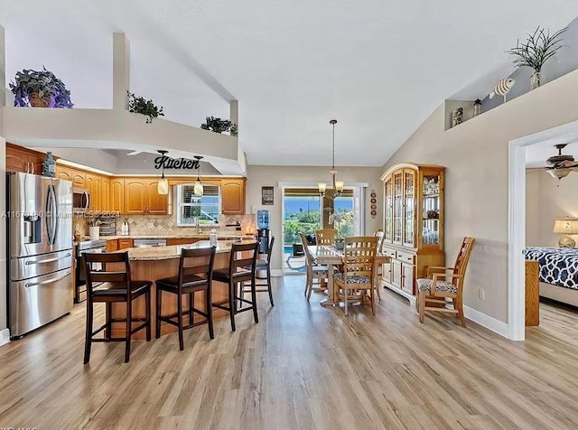 kitchen with decorative backsplash, light hardwood / wood-style flooring, stainless steel appliances, decorative light fixtures, and an inviting chandelier