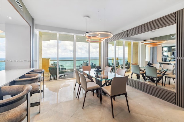 sunroom featuring a water view and an inviting chandelier