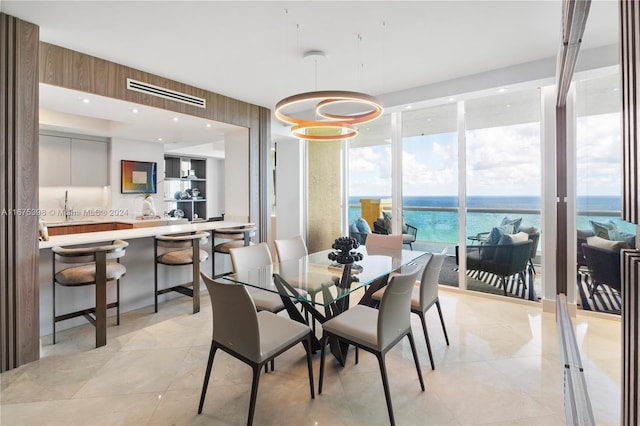 dining room featuring light tile patterned floors and a water view