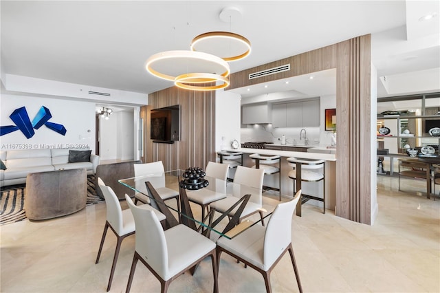 tiled dining room featuring an inviting chandelier and sink