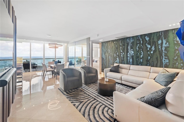 living room featuring light tile patterned flooring, a water view, and a wall of windows