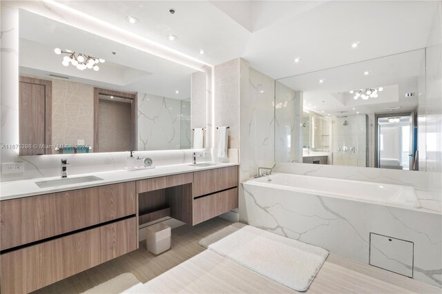 bathroom with plus walk in shower, vanity, tile walls, and hardwood / wood-style flooring