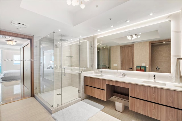 bathroom with vanity, a raised ceiling, and a shower with door