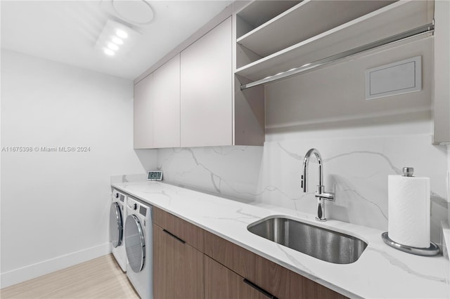 kitchen with decorative backsplash, light stone counters, separate washer and dryer, light hardwood / wood-style flooring, and white cabinets