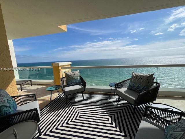 balcony featuring a beach view and a water view