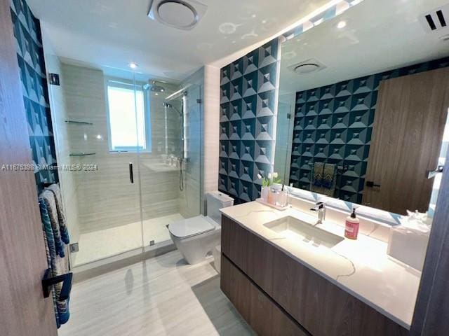 bathroom featuring vanity, toilet, a shower with door, and tile walls