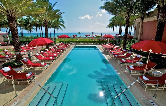 view of pool with a water view and a patio