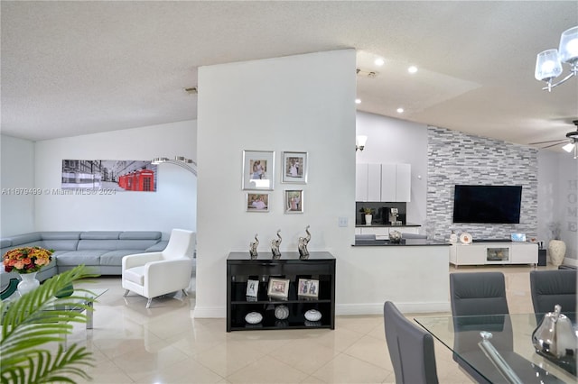 tiled living room featuring ceiling fan, a textured ceiling, and lofted ceiling