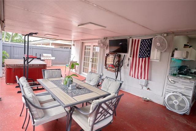 view of patio with a hot tub, fence, french doors, outdoor dining area, and grilling area