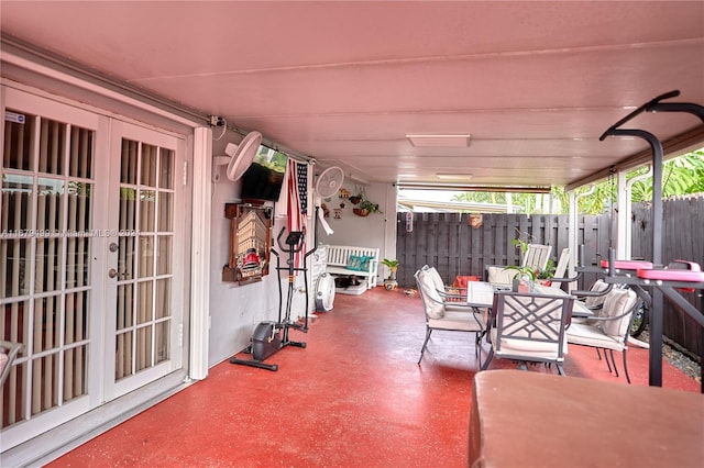 view of patio with french doors, fence, and outdoor dining area