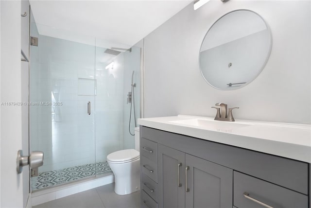 bathroom featuring walk in shower, vanity, tile patterned floors, and toilet