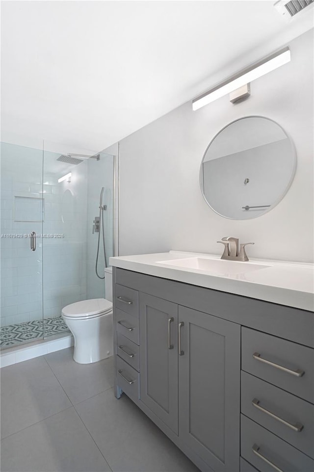 bathroom with toilet, a shower with door, tile patterned floors, and vanity