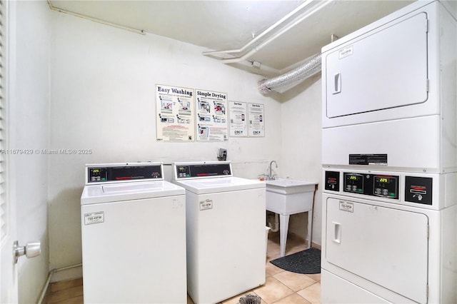 laundry room with stacked washing maching and dryer, light tile patterned flooring, and independent washer and dryer