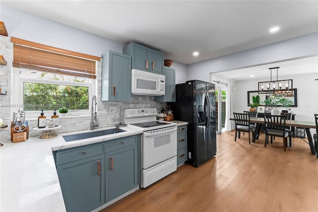 kitchen with light hardwood / wood-style flooring, sink, pendant lighting, blue cabinets, and white appliances