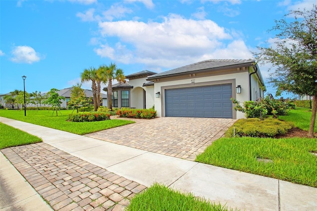 view of front of home featuring a garage, a front yard, decorative driveway, and stucco siding