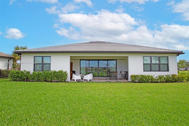 back of property with a patio and a yard