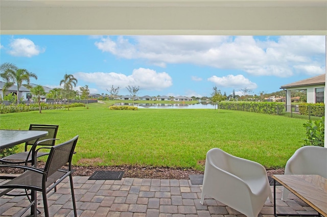 view of yard with a water view, fence, and a patio