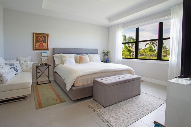 tiled bedroom featuring a tray ceiling