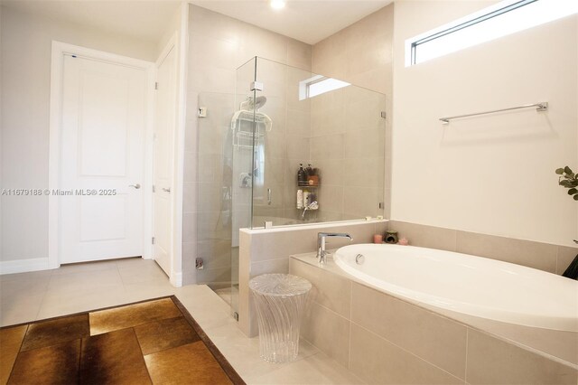 full bath with a stall shower, tile patterned flooring, and a bath