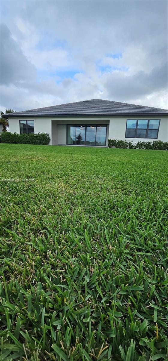 4527 Blessed Place Dr, Oakland Park, FL 33309 - rear view of house featuring stucco siding and a yard