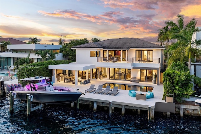 back house at dusk featuring a water view