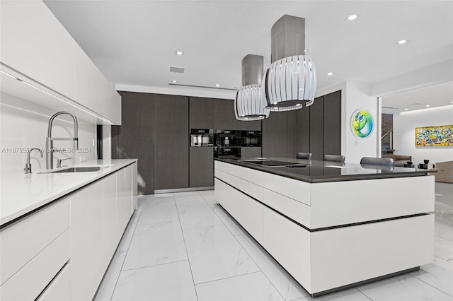 kitchen featuring white cabinets, backsplash, black electric cooktop, dark brown cabinetry, and sink