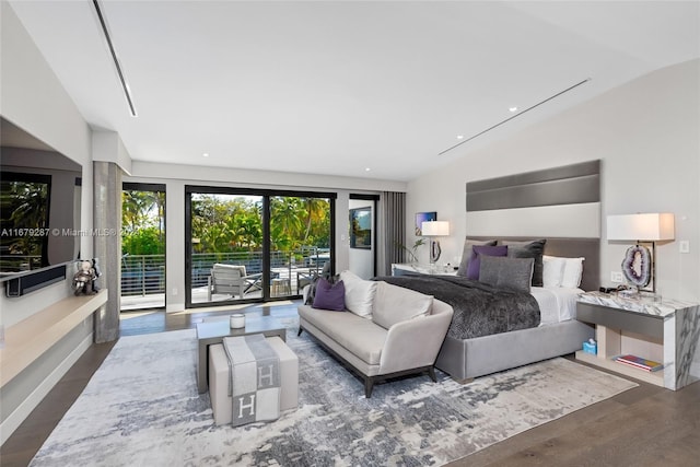 bedroom featuring lofted ceiling, access to exterior, and dark hardwood / wood-style flooring