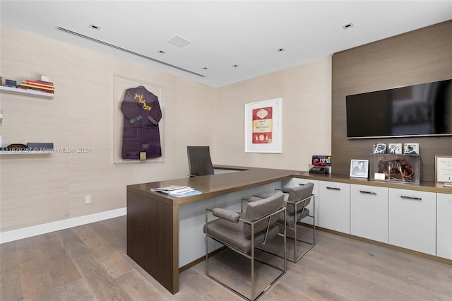 office space with built in desk and light wood-type flooring