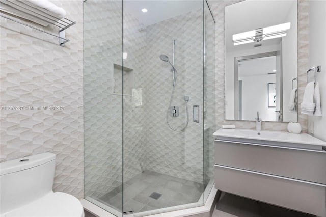 bathroom with tile walls, vanity, toilet, and an enclosed shower